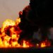Une violente explosion, accompagnée de flammes éclatantes et d'une épaisse fumée noire, emplit le ciel au crépuscule.
