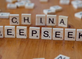 Gros plan de tuiles de Scrabble en bois portant les mots « China » et « Deepseek » sur une surface en bois.