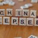 Gros plan de tuiles de Scrabble en bois portant les mots « China » et « Deepseek » sur une surface en bois.