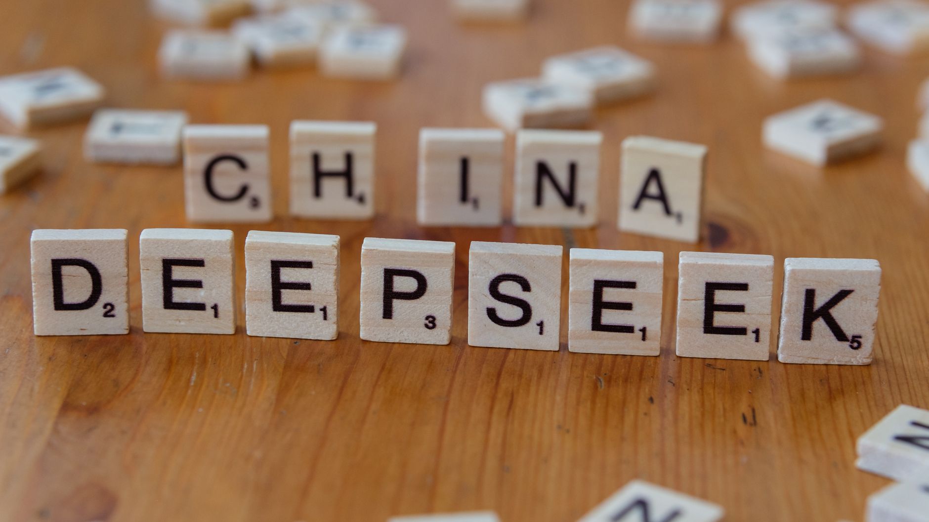 Gros plan de tuiles de Scrabble en bois portant les mots « China » et « Deepseek » sur une surface en bois.