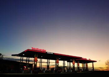Une station-service sous un ciel d'aube dramatique capturant l'ambiance calme du petit matin.