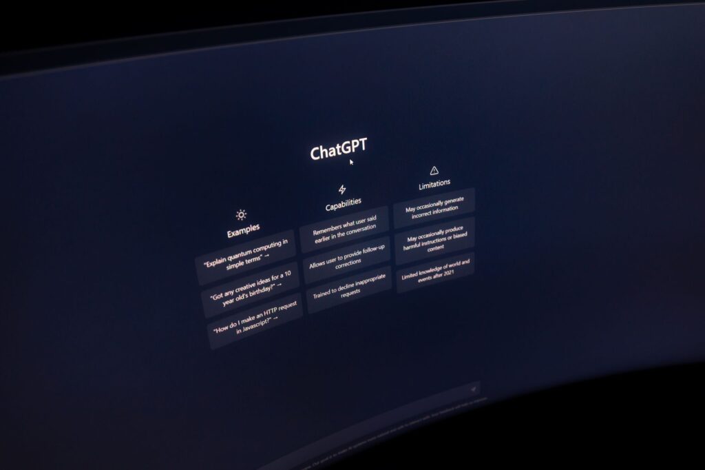 Gros plan sur un écran d'ordinateur affichant l'interface de ChatGPT dans un environnement sombre.