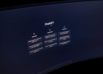 Gros plan sur un écran d'ordinateur affichant l'interface de ChatGPT dans un environnement sombre.