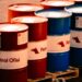 Une collection de barils de pétrole rouges et bleus étiquetés 'Ofisi de Pétrole' dans un cadre industriel en plein air en Turquie.