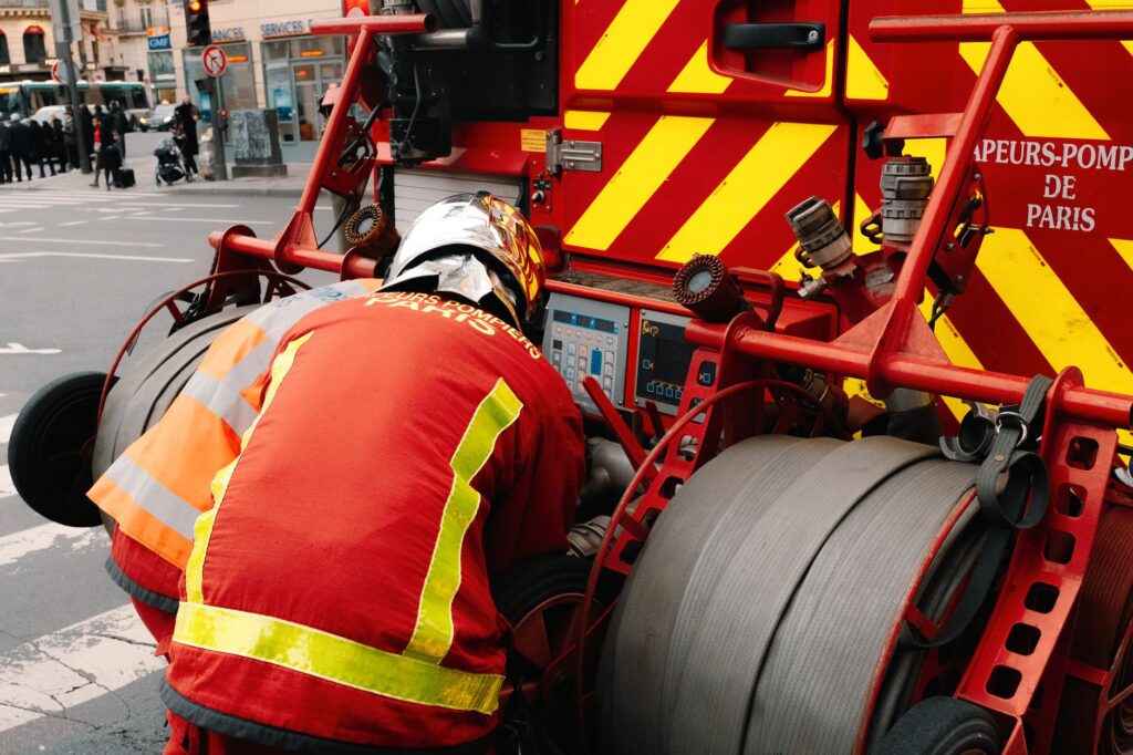 Pompiers utilisant l'équipement sur un camion de pompier à Paris, garantissant la sécurité publique.