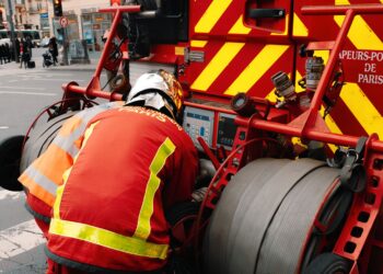 Pompiers utilisant l'équipement sur un camion de pompier à Paris, garantissant la sécurité publique.