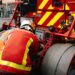 Pompiers utilisant l'équipement sur un camion de pompier à Paris, garantissant la sécurité publique.
