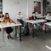 Groupe divers d'étudiants apprenant attentivement dans une salle de classe lumineuse.