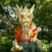 Gros plan sur une statue de dragon au milieu d'une végétation luxuriante à Fujisawa, au Japon, illustrant une beauté mythique.