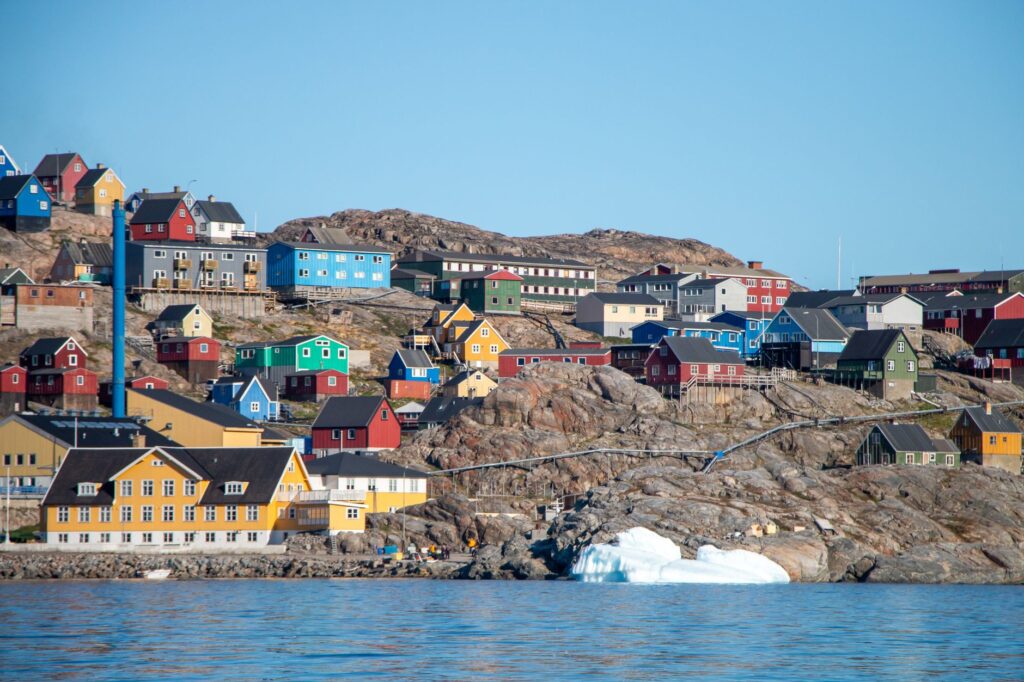 Maisons de village côtières animées à Uummannaq, au Groenland, avec des eaux glacées.