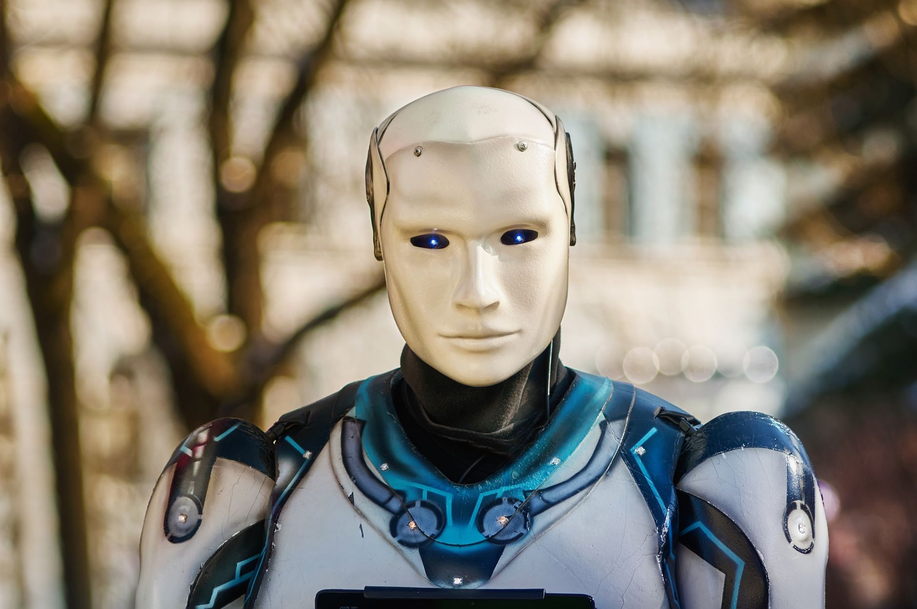 Gros plan sur un robot humanoïde au design futuriste posant en extérieur.